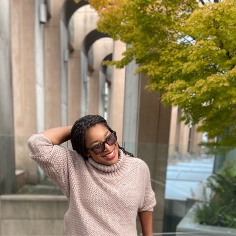 Alexis Verdicchio, founder of Upcycled Unity, smiling outdoors during a community wellness gathering in Vancouver.